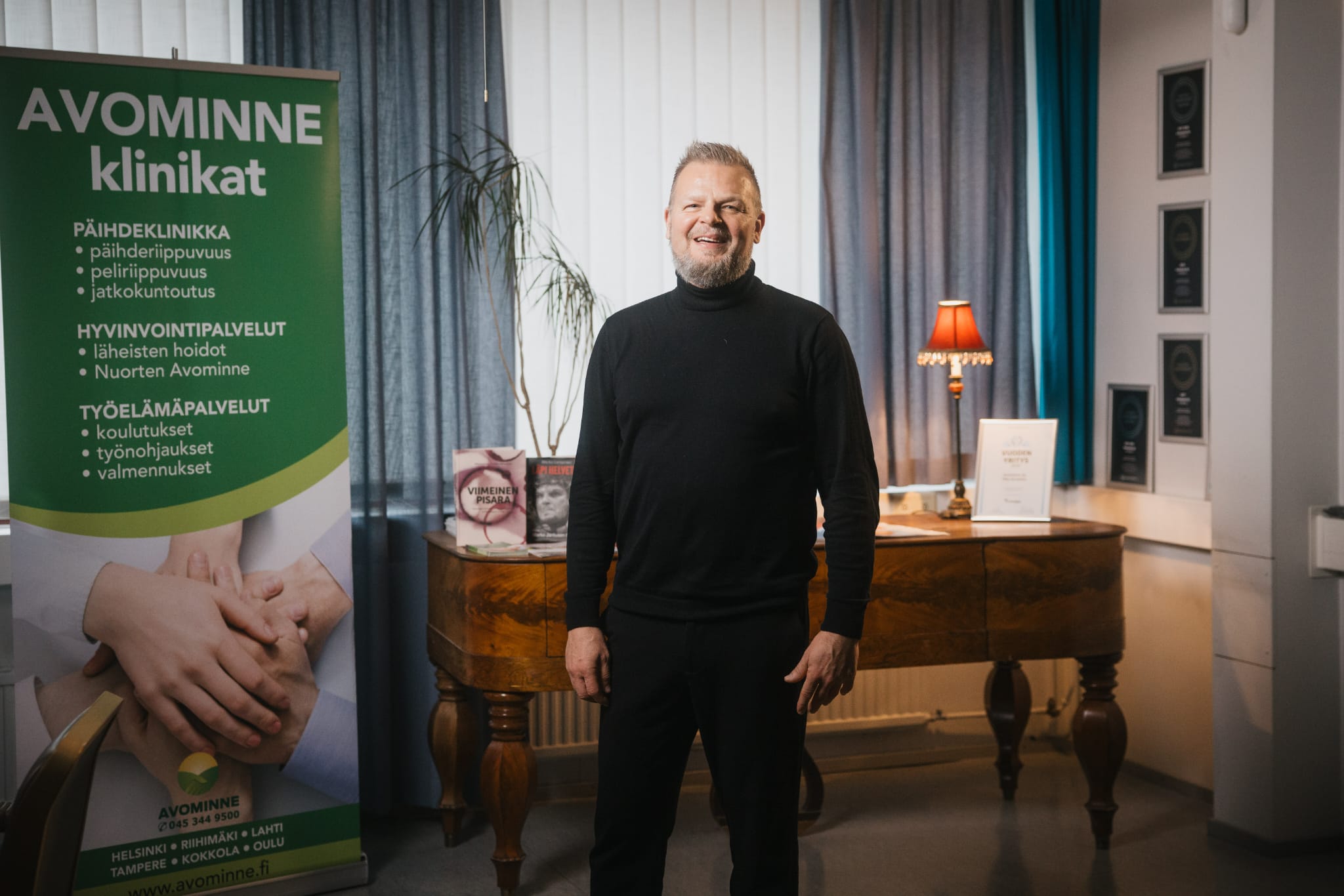 Marko Jantunen seisoo Avominne-klinikoiden vastaanottotiloissa hymyillen.